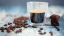 schwarzer Kaffee Gene: Tasse mit schwarzem Kaffee, Kaffeebohnen und dunkle Schokolade