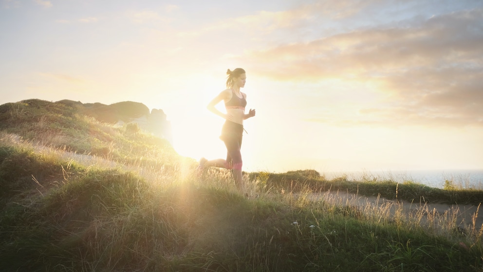 Morgensport Abendsport Gesundheit: Frau läuft bei Sonnenaufgang querfeldein