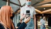 ungültiges zertifikat booster: Frau lässt ihr Handy im Restaurant scannen