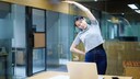 Mikro-Workouts Gesundheit: Frau macht Gymnastik im B&uuml;ro