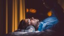 Mann liegt mit Kopfhörern und Tablet im Bett