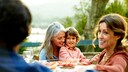 Mehre Generationen sitzen glücklich am Esstisch