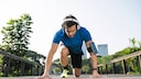 Sportkopfhörer: Läufer mit Kopfhörern in Startposition
