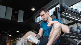 Ein junger Mann mit Protein-Shake im Gym