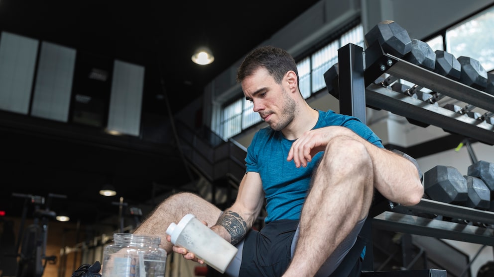 Ein junger Mann mit Protein-Shake im Gym