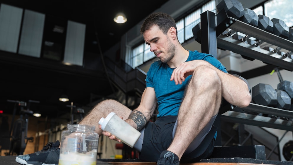 Ein junger Mann mit Protein-Shake im Gym