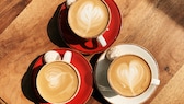 tassen kaffee herz: Drei Tassen Kaffee auf einem Holztisch