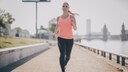 laufen lebenserwartung: Junge Frau joggt am Wasser