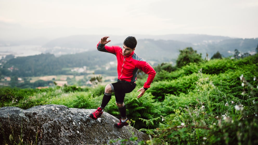 Trailrunner springt auf einen Stein