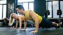 fit bleiben 10 minuten: Zwei Männer und eine Frau machen Liegestütze