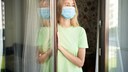 quarantäne freiwillig: Junge Frau zu Hause mit Maske
