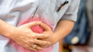 Mann hält sich vor Schmerz den Bauch