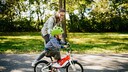 kauf kinderfahrrad: Mutter schiebt ihr Kind auf dem Rad