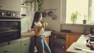 Intervallfasten 16:8: Frau trinkt Tee in Küche