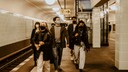 warum nicht mit corona infiziert: Gruppe junger Menschen mit Masken in einer U-Bahn-Station
