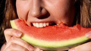 Wassermelone weißer Rand essen: Frau beißt in Wassermelone