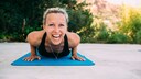 Junge Frau lacht in Yoga-Pose