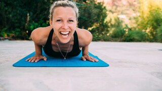 Junge Frau lacht in Yoga-Pose