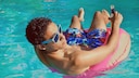 Jugendlicher im Schwimmreif und mit Alkohol im Poll
