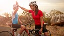 Zwei Frauen auf dem Rennrad geben sich High-Five