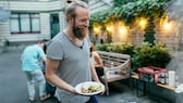 mediterrane ernährung männer: Junger Mann mit Essen in der Hand