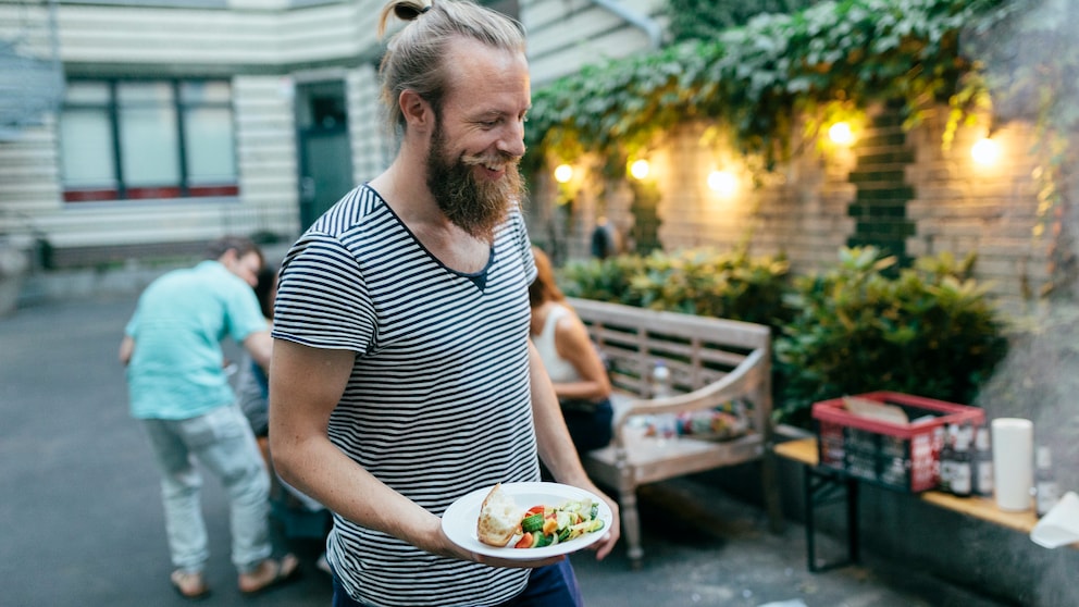 mediterrane ernährung männer: Junger Mann mit Essen in der Hand