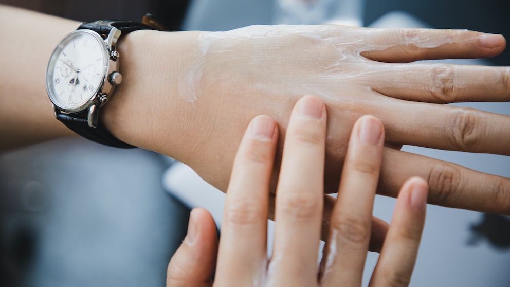 Anzeichen Proteinmangel: Frau trägt Lotion auf