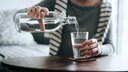 Frau schenke sich Wasser ein