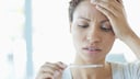 Frau mit Fieberthermometer