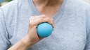Mann drückt auf einen kleinen Ball in seiner Hand
