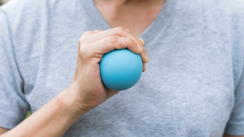 Mann drückt auf einen kleinen Ball in seiner Hand