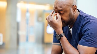Long-Covid-Risiko mentale gesundheit: Mann mit einer Hand an der Stirn