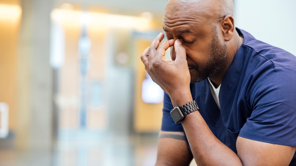 Long-Covid-Risiko mentale gesundheit: Mann mit einer Hand an der Stirn