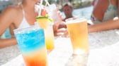 Junge Menschen mit Cocktails am Pool