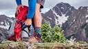 Mann greift in Wanderrucksack zu seinen F&uuml;&szlig;en