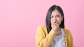 Frau hat metallischen Geschmack im Mund