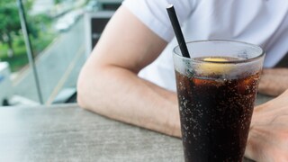 zucker Bewegung Männer: Mann trinkt Cola, neben ihm lacht eine Frau