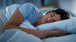 Junger Mann schläft auf der Seite mit Kopfkissen