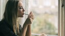 zigaretten wirkung frauen: eine Frau sitzt am Fenster und raucht