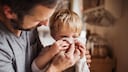 Infekte Kinder: Vater hilft Sohn beim Naseputzen