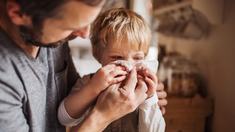 Infekte Kinder: Vater hilft Sohn beim Naseputzen