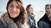 Drei junge, lächelnde Menschen am Nordseestrand