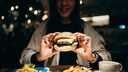 Frau isst Burger und Pommes