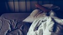 Frau liegt unter Kissen im Bett