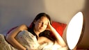 Frau im Bett mit Tageslichtlampe oder Lichtwecker