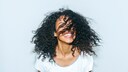 Biotin vitamin B7: Fröhliche Frau mit lockigen Haaren