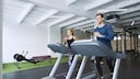 Zwei Personen auf einem Laufband
