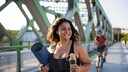 sport übergewicht: Junge kurvige Frau im Sport-Outfit mit Yoga-Matte und Trinkflasche