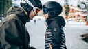 Vater und Sohn in Winterbekleidung und mit Skihelm und Brille