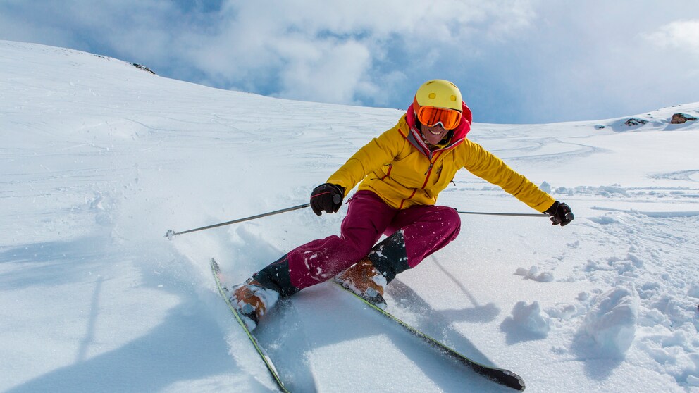 wintersport gefährlich: Mann mit Skiern auf der Piste